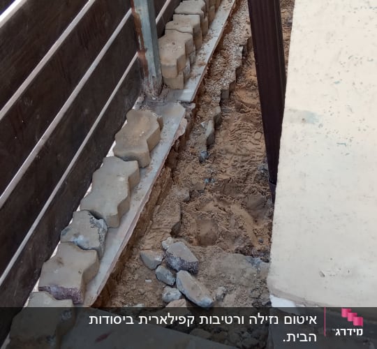 כלי עבודה וחול ליד גדר עץ